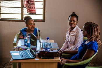 three women filling out forms on computers for an interception